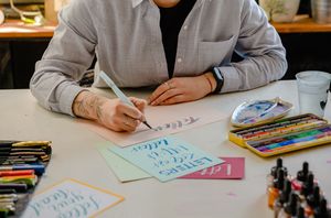 Lettering with brush pens and inks on a desk, photo by AI25.Studio on Pexels