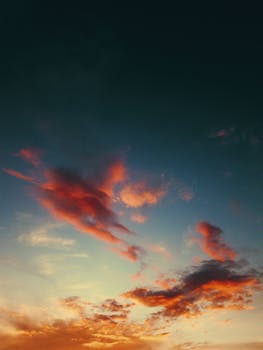 A colorful and dramatic sunset sky with vivid clouds painted in warm hues captured during twilight.