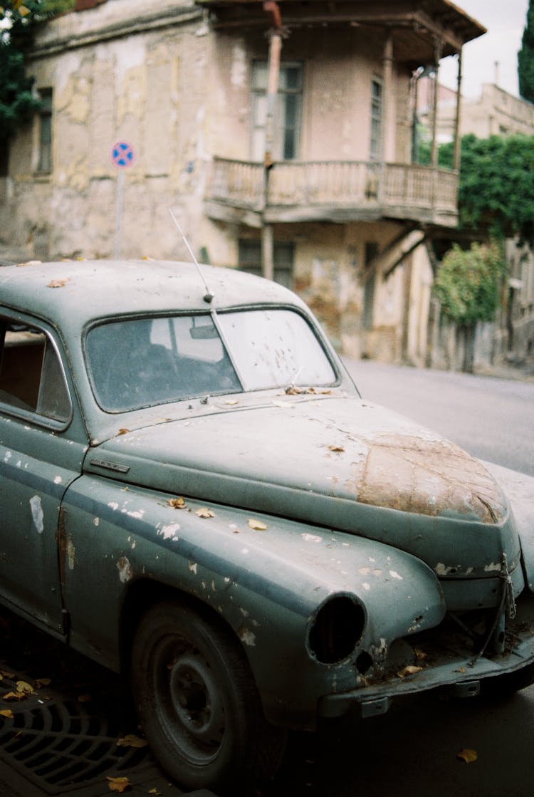 Retro Car Parked Near Abandoned House On City Street