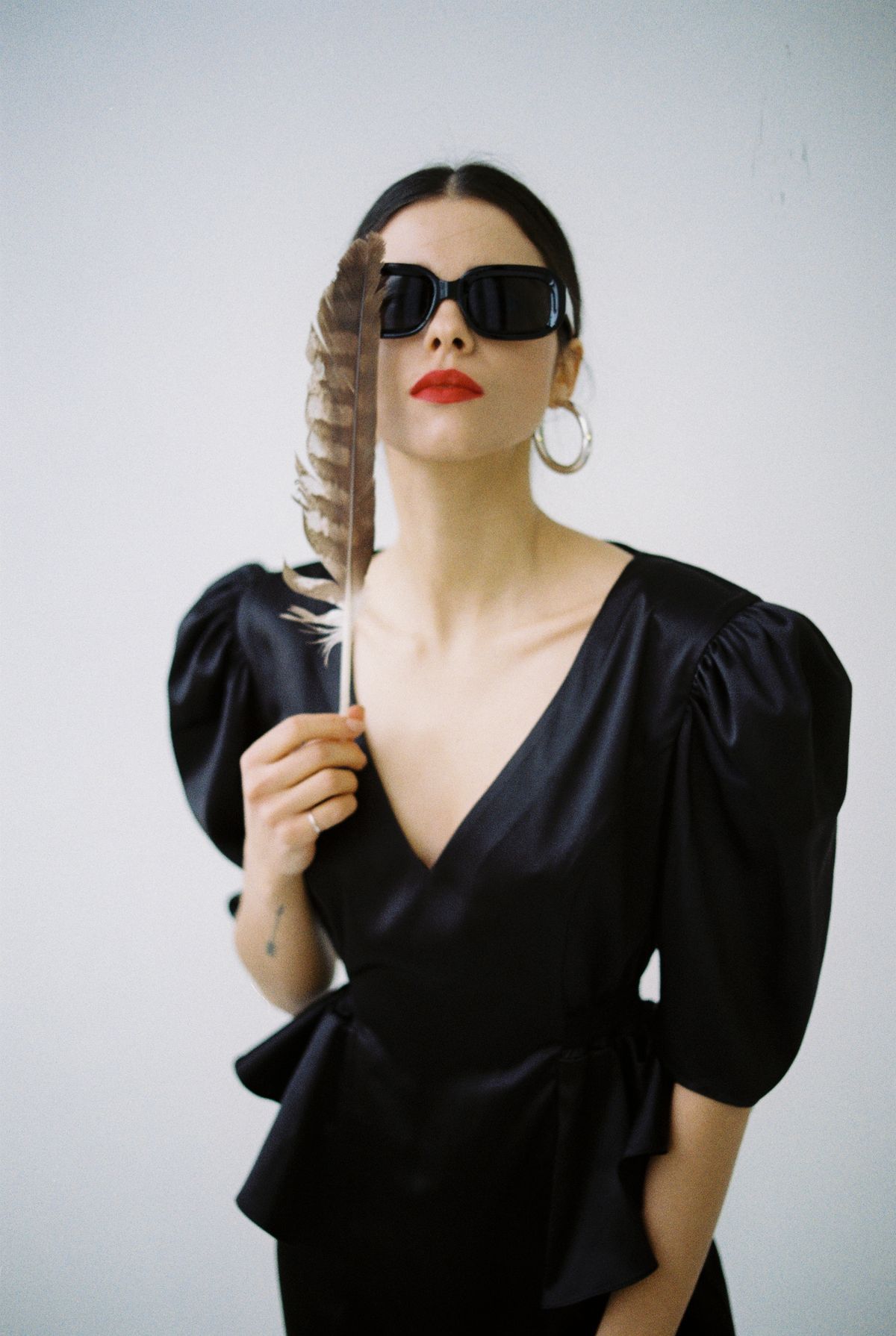 A fashionable woman in a black outfit with sunglasses — styling the black dress