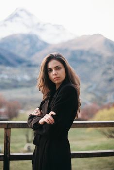 在风景如画的山区背景下，一位年轻女子自信地看着镜头