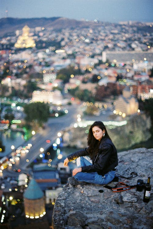 Free Unemotional woman sitting above city Stock Photo