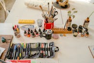 从高角度俯瞰，一张井然有序的办公桌上摆放着各种艺术用品，非常适合创意和工艺爱好者