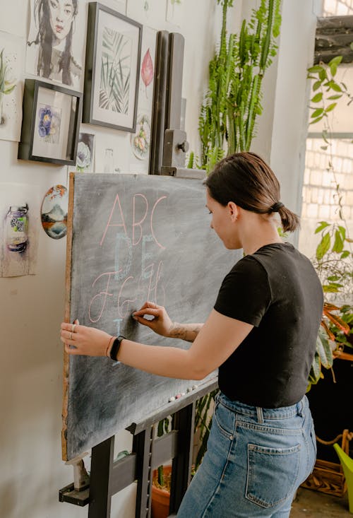Woman in Black Shirt  Writing on the Chalkboard