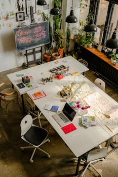 创意艺术工作空间的俯视图中，大桌子上摆放着书法工具和用品