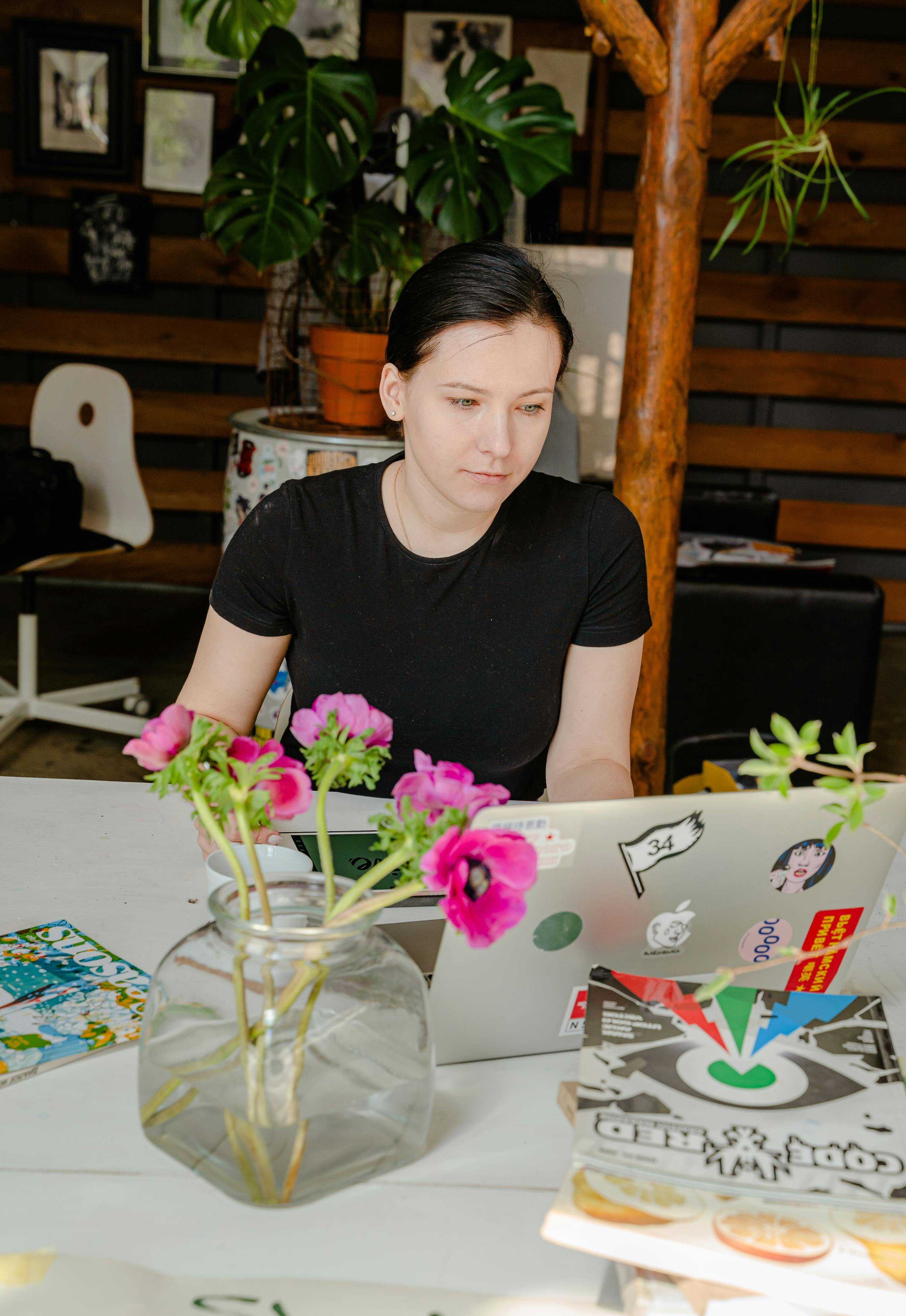 photo of woman in black shirt sitting by the table