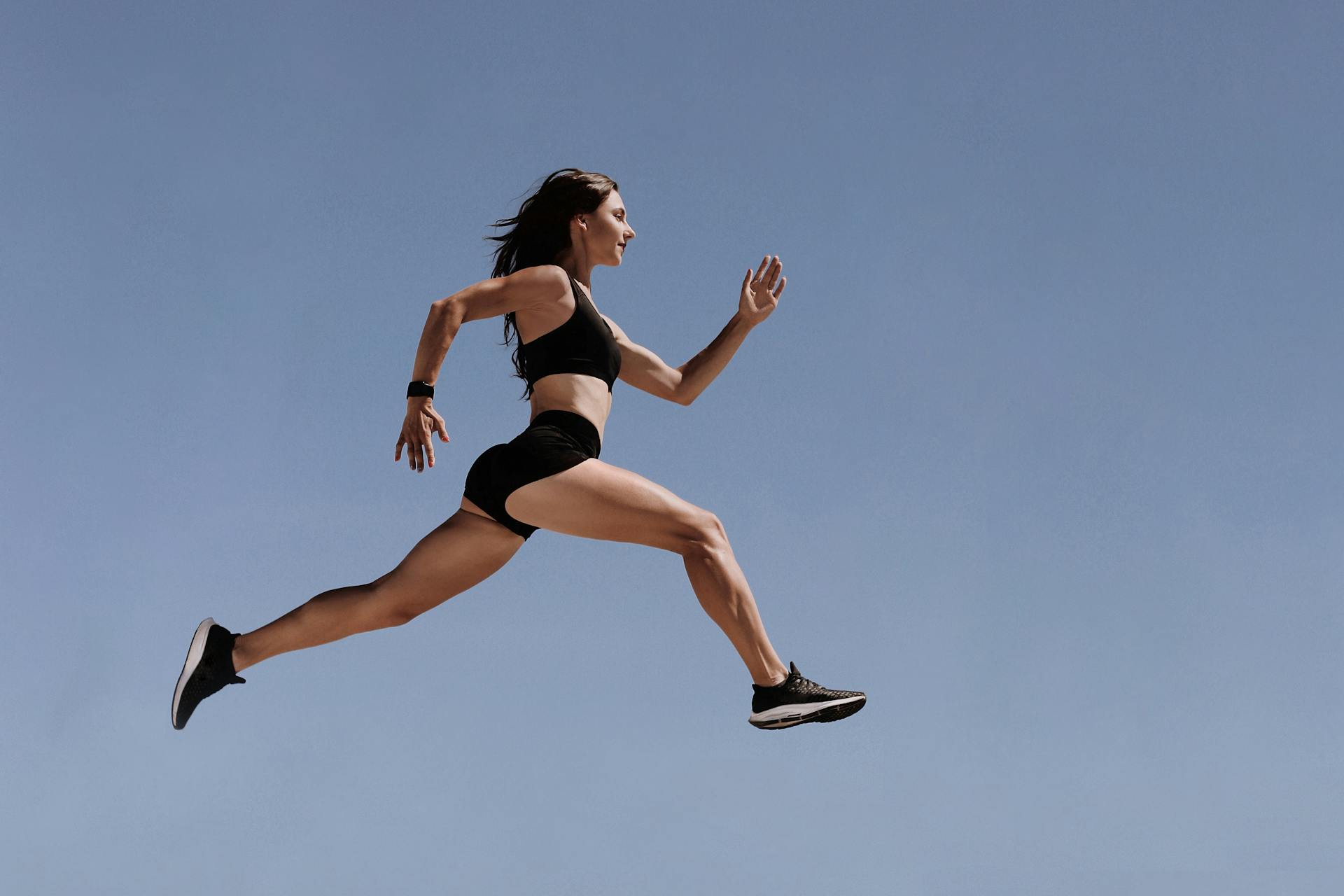 Woman in Black Sports Bra and White Shorts Jumping