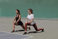 Pretty Women Stretching in the Athletic Field