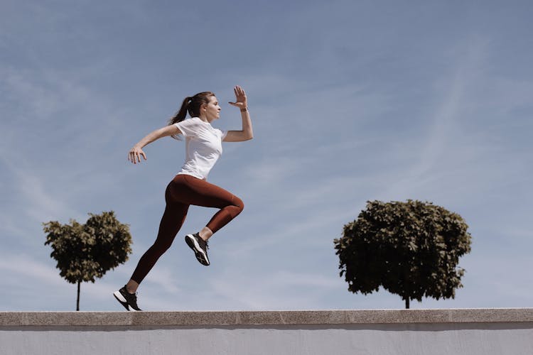 Woman In White Shirt And Leggings Running 