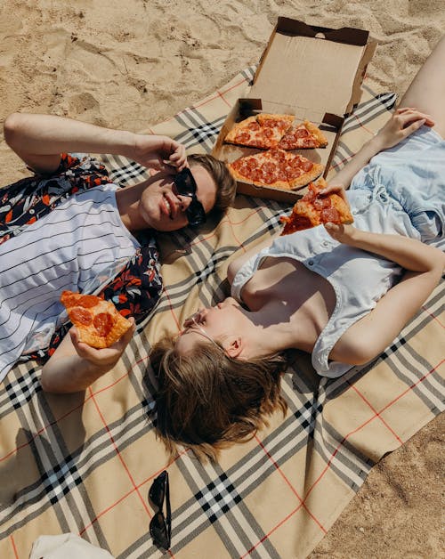 Free Couple Lying Down Eating Pizza Stock Photo