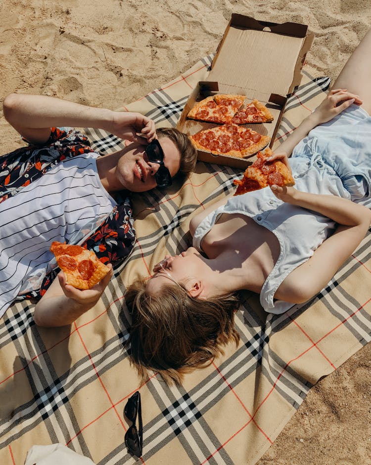 Couple Lying Down Eating Pizza