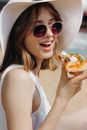 Woman in White Tank Top Holding Sliced of Pizza