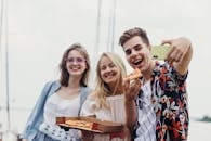 一群朋友在户外享用披萨、欢笑自拍，捕捉到了完美的夏日