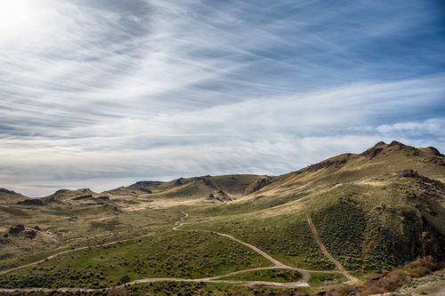 Free Picturesque view of mounts with grass and narrow paths under blue sky with clouds Stock Photo