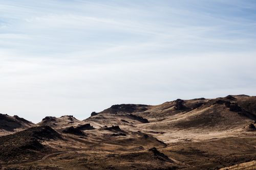 Free From below scenery view of uneven brown ridge under cloudy sky in daylight Stock Photo