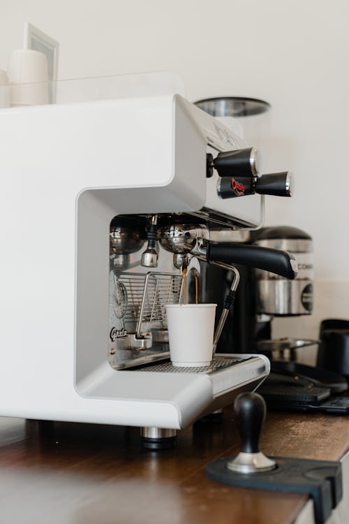 Free Professional coffee machine pouring coffee in paper cup Stock Photo