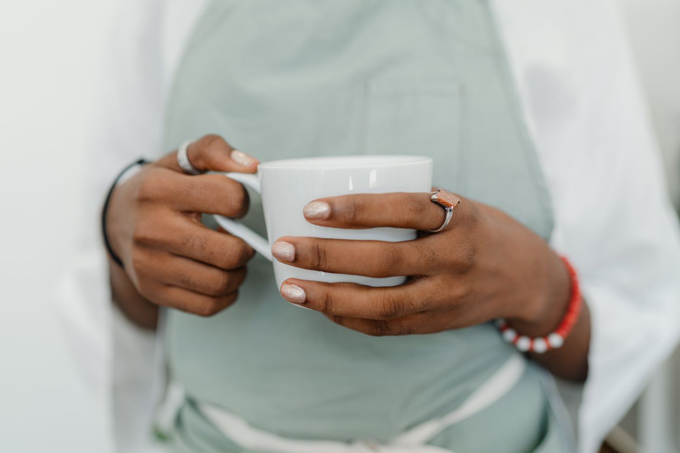 Two hands cradling a warm white mug