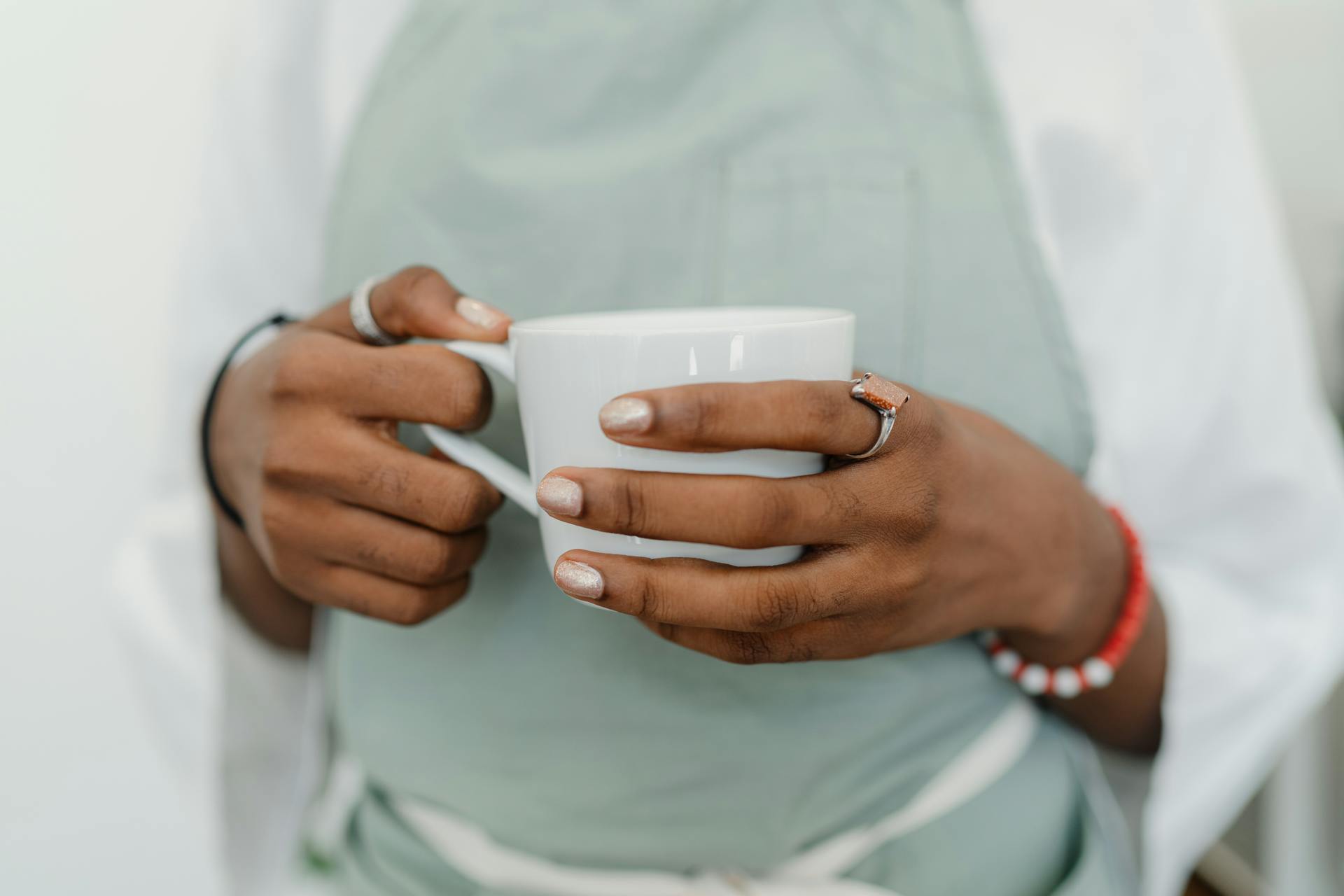 Crop young black woman in apron in coffee shop