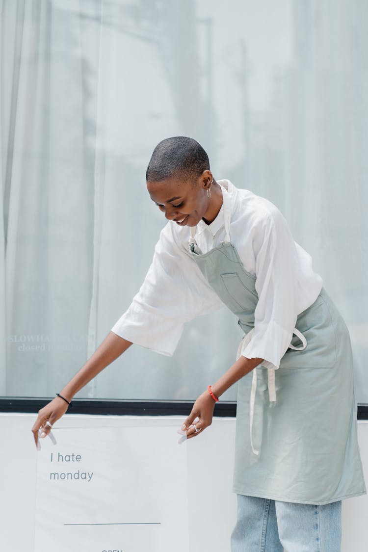 Smiling Black Female Worker Placing Signboard Outside Cafeteria