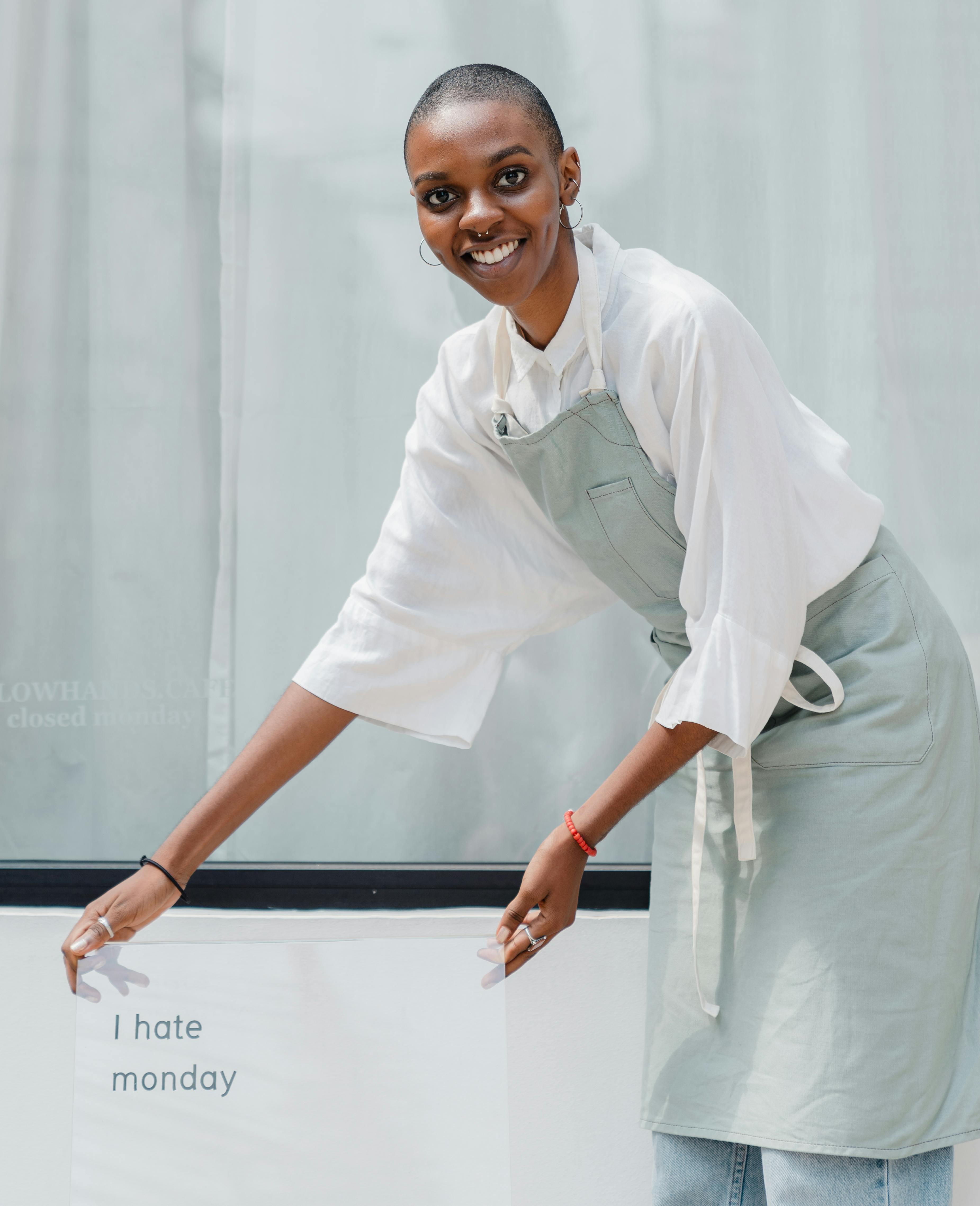happy black female worker setting signboard outside cafeteria