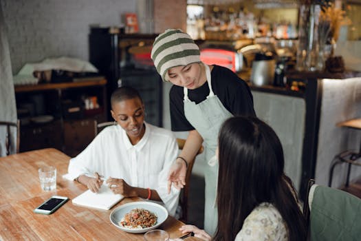 A diverse group enjoys a friendly conversation with staff in a stylish cafe.