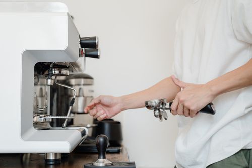 Free Close-up of a barista using an espresso machine indoors. Perfect for coffee-related content. Stock Photo