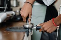 特写镜头中，咖啡师在咖啡店用搅拌器准备浓缩咖啡