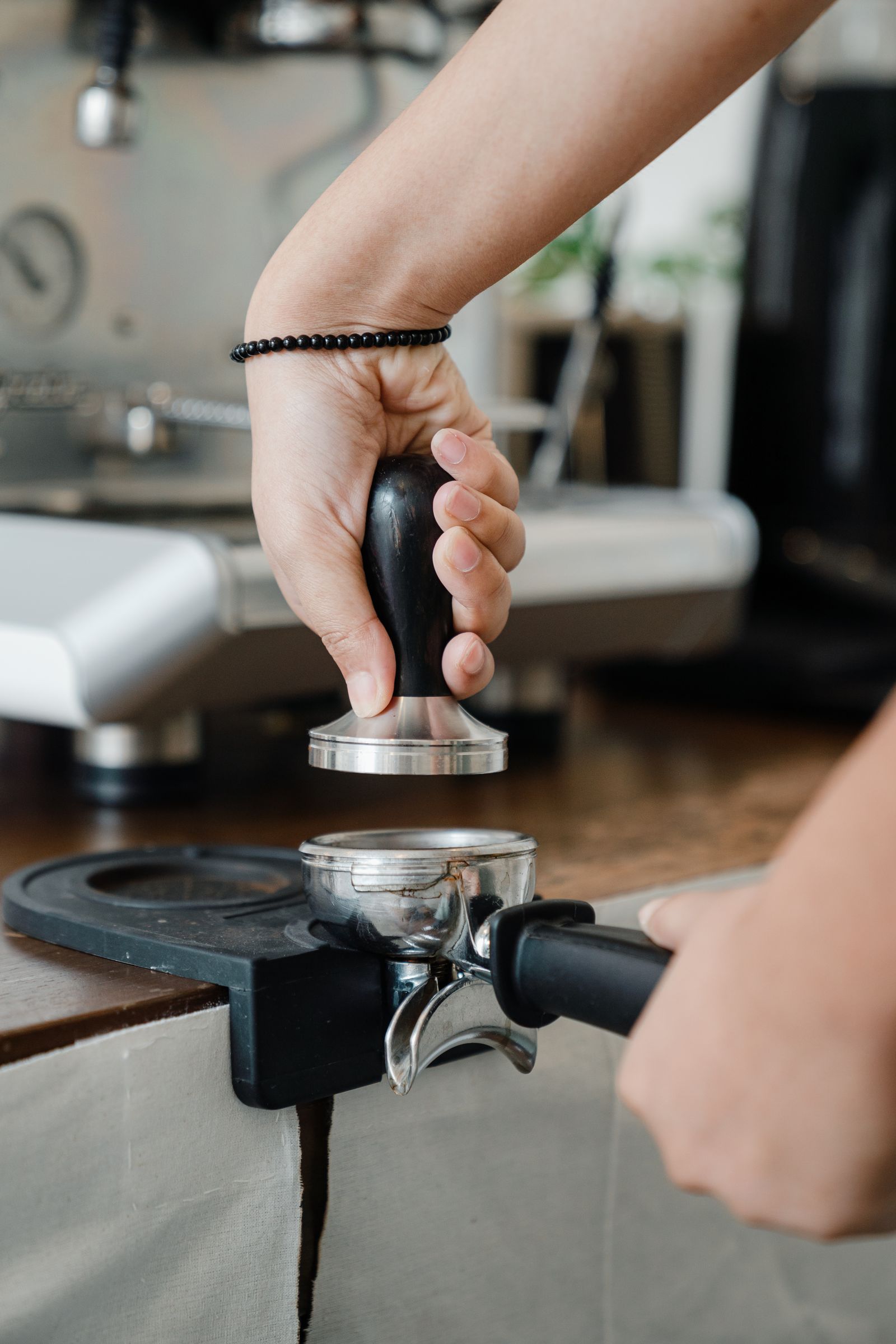 Barista manually tamping coffee in a portafilter