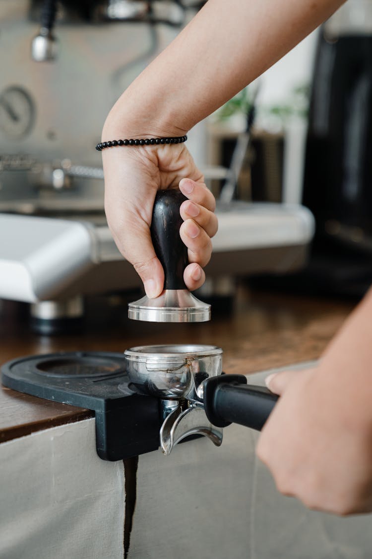 Crop Barista Putting Tamper On Portafilter