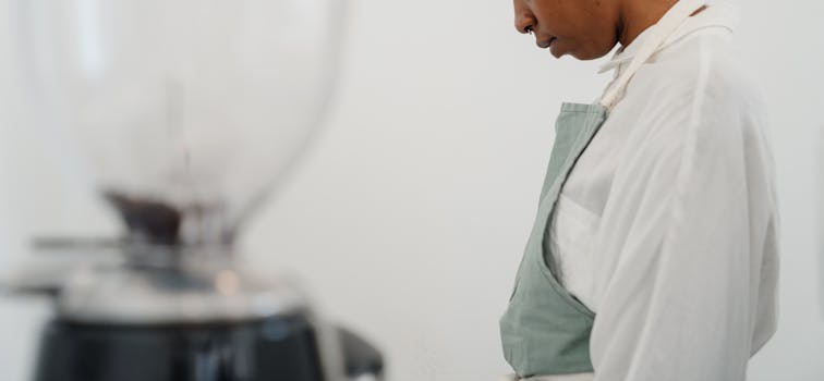 A focused barista in a café setting preparing coffee, emphasizing professionalism and dedication.