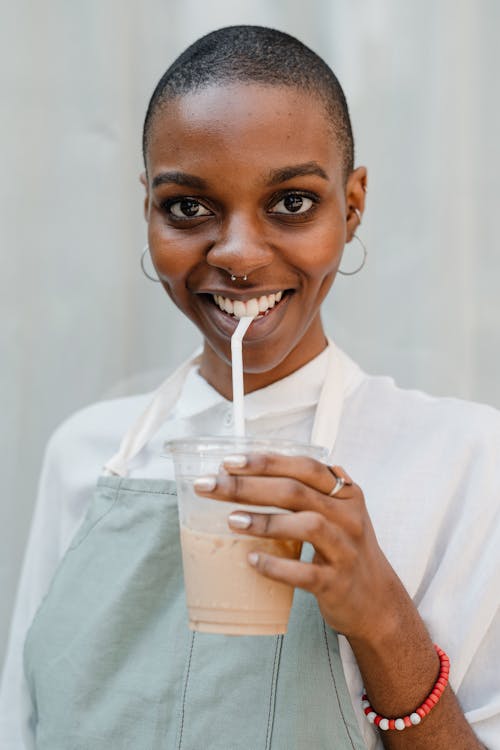 Free Photo of Woman Smiling While Holding Disposable Cup With Coffee Stock Photo