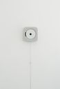 White wall mounted CD player against white wall