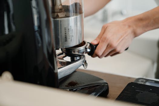 Close-up of a barista grinding coffee for a fresh espresso in a modern café.
