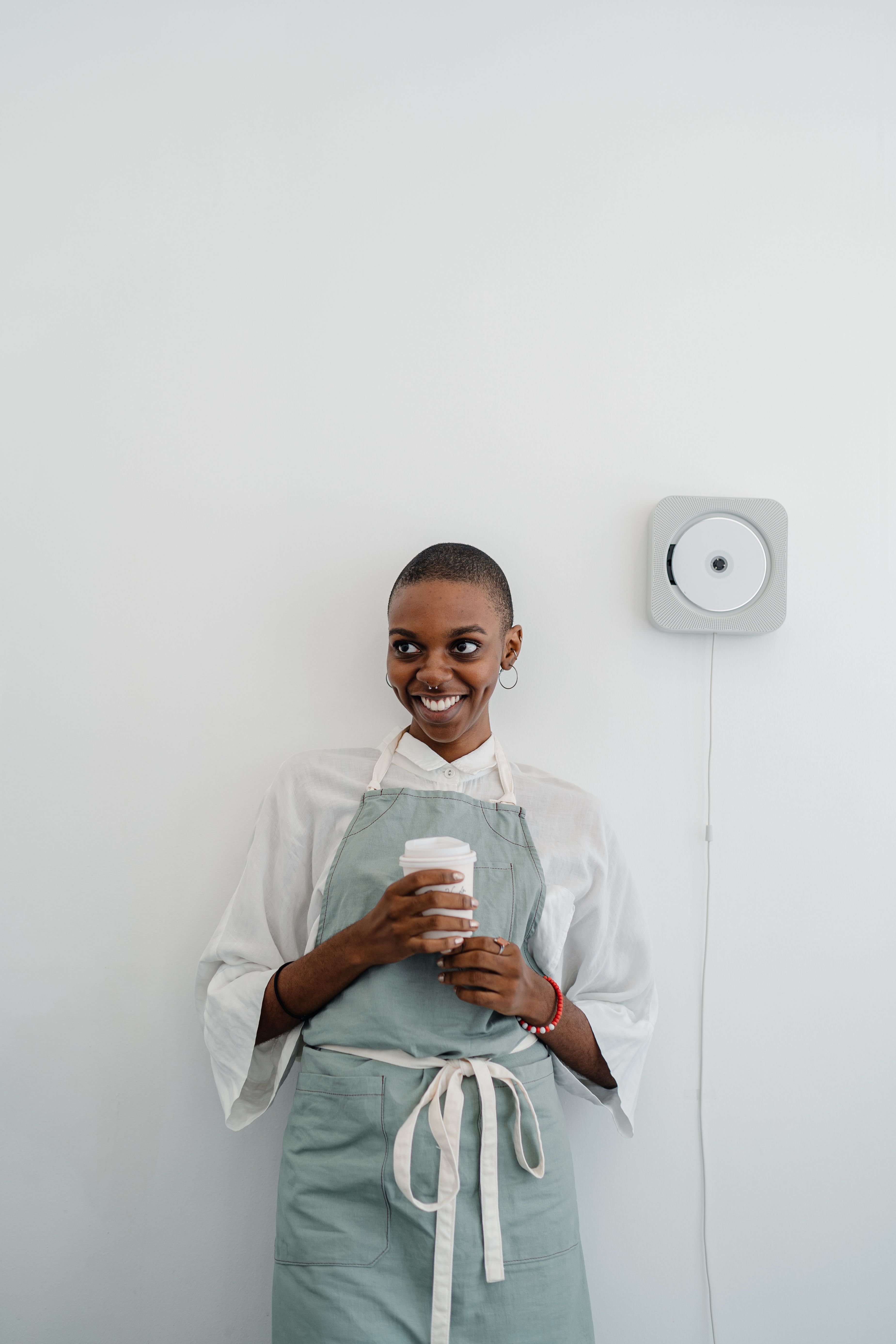 Photo of Woman in White Long Sleeve Shirt and Apron While Holding a Cup ...