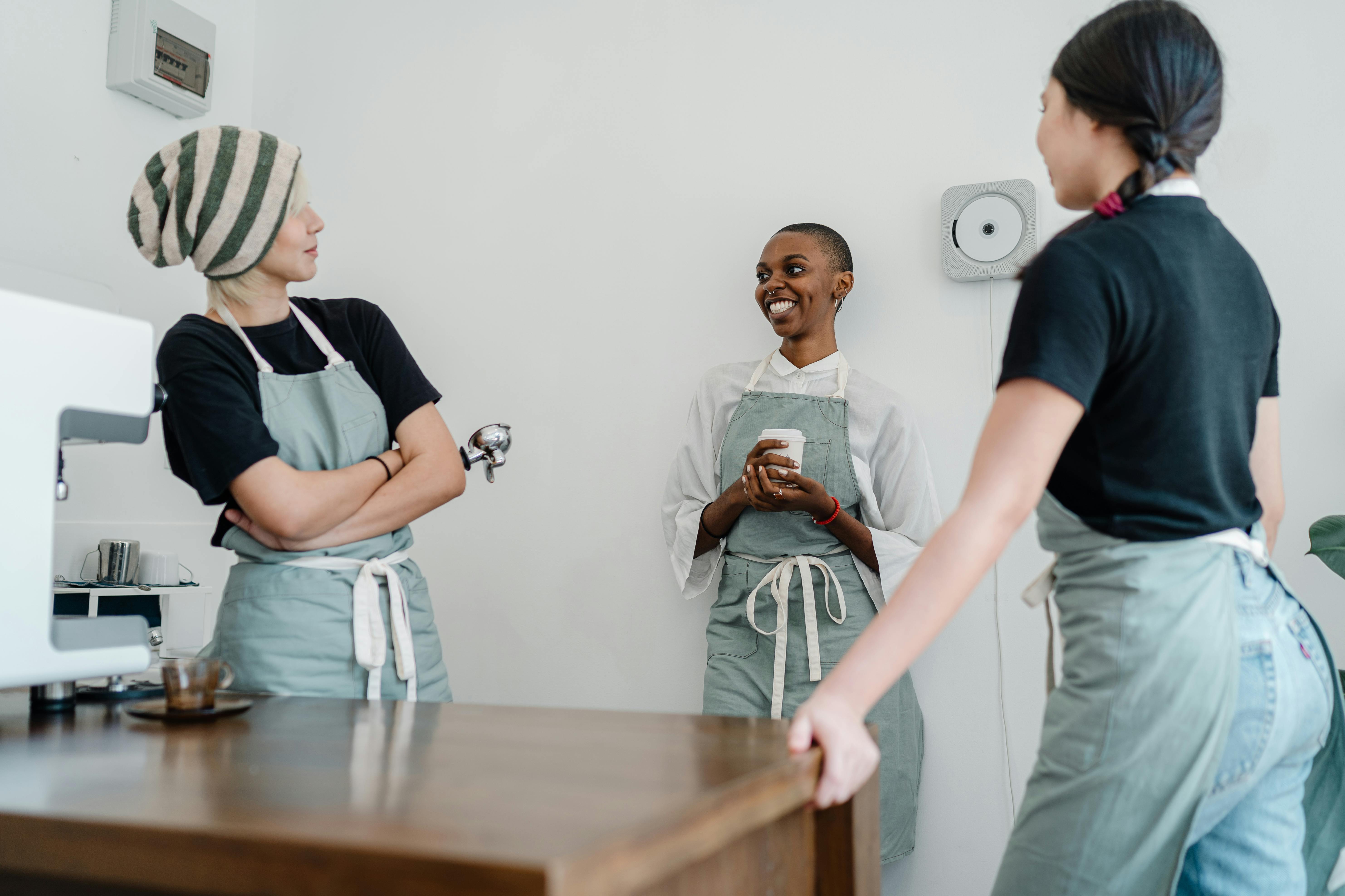 photo of three women standing while talking to each other