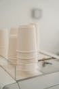 Set of various white paper cups placed on coffee machine in modern cafe