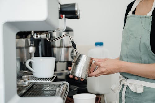 Free Crop anonymous woman making hot drink with coffee machine Stock Photo