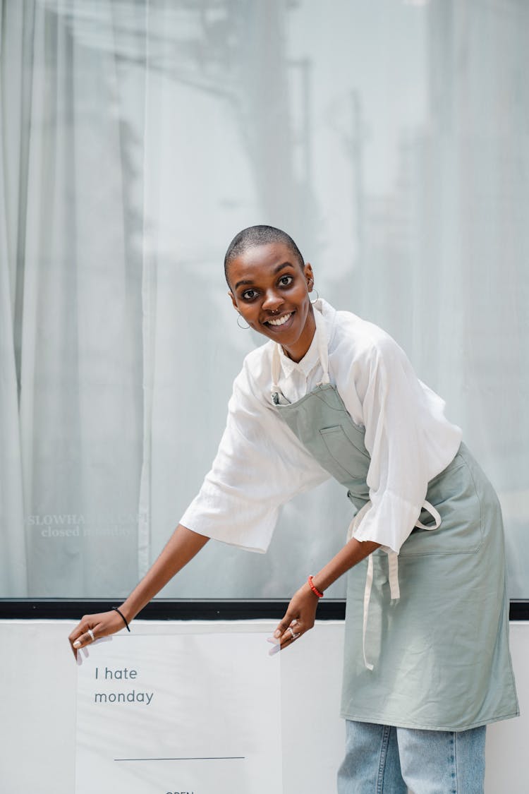 Cheerful Young Black Waitress Showing Board With Creative Inscription