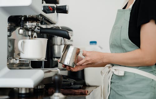 Free Crop young barista preparing fresh latte in cafe Stock Photo