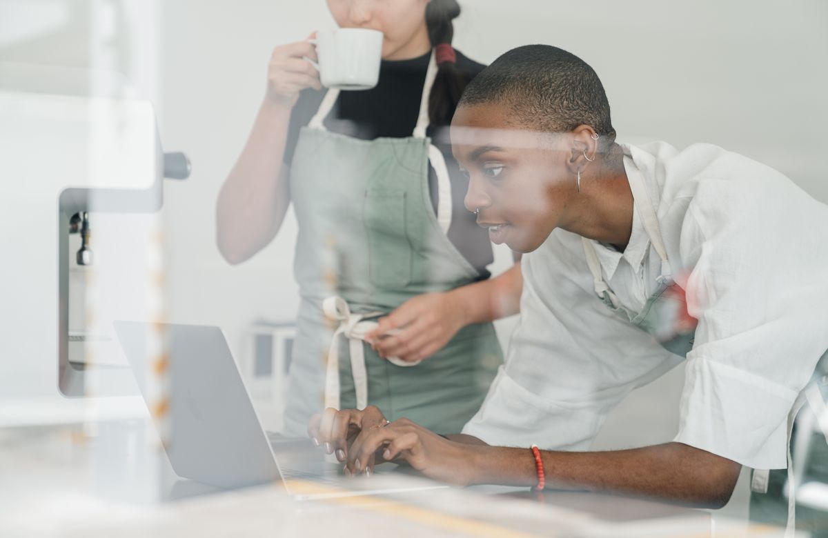 Kenyan hospitality professional working on a laptop in a modern Nairobi hotel office