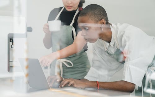 Free Colleagues at coffee shop using special program on laptop together Stock Photo