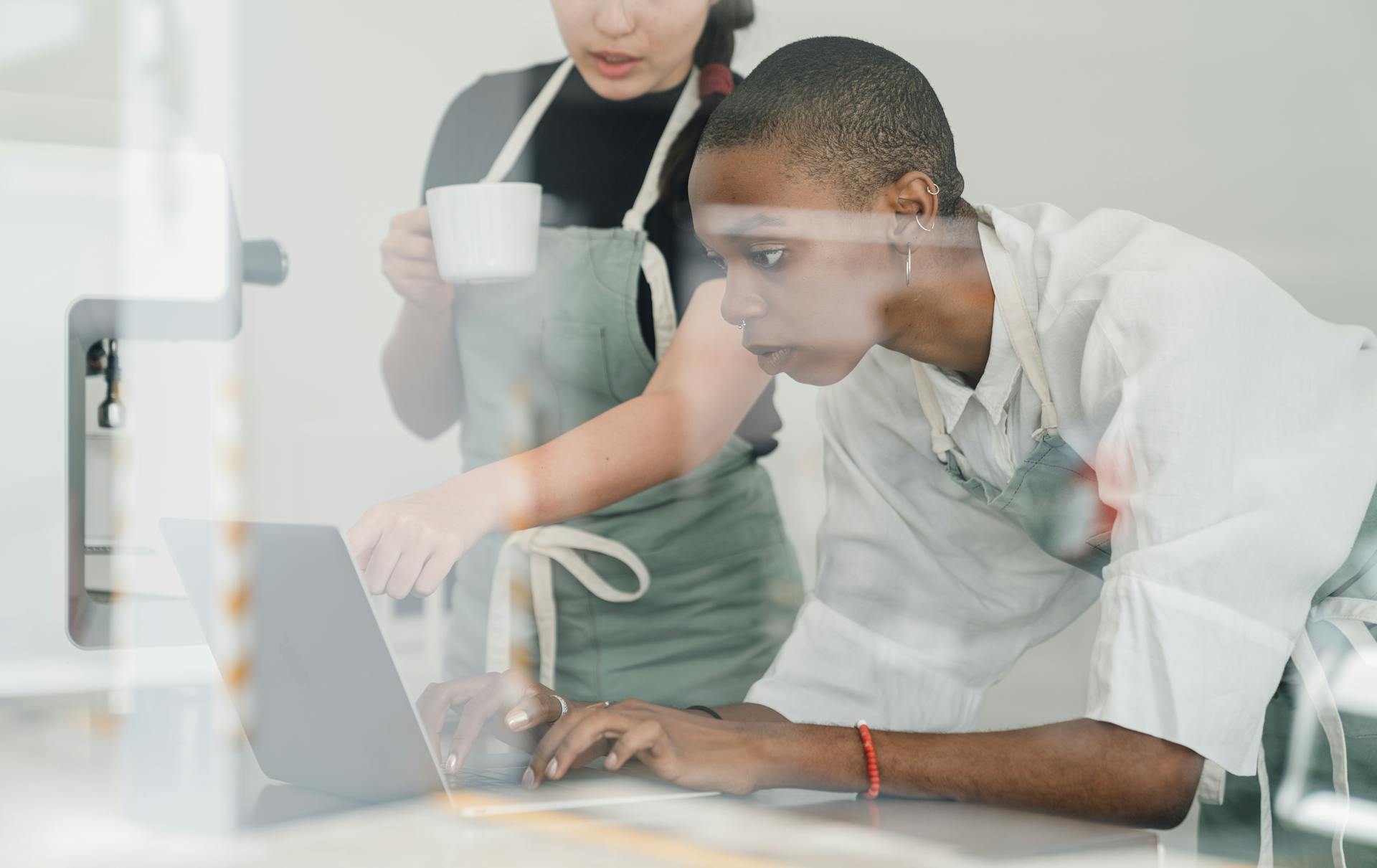 Colleagues at coffee shop using special program on laptop together