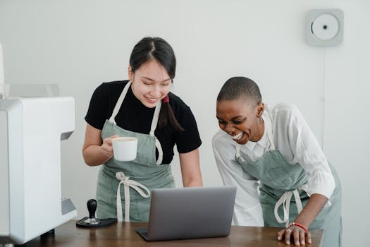 Young baristas laughing together during a coffee break in a modern café, enjoying their time.