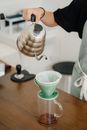 Crop barista brewing coffee with pourover filter