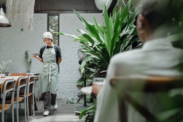 Calm Waitress Carrying Plate With Guest Order