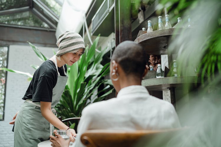 Glad Waitress Serving Food To Customer