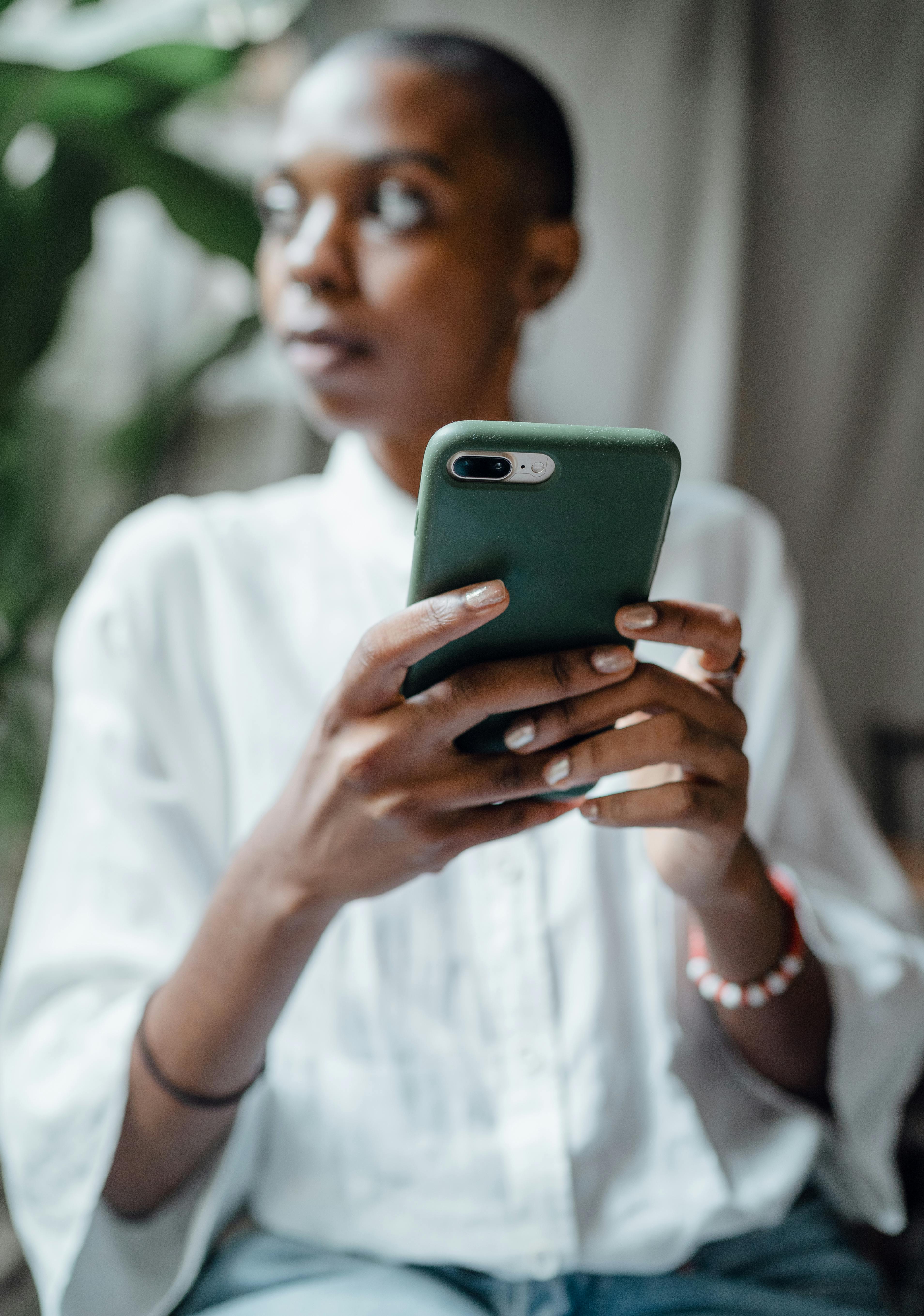 black woman using smartphone and looking away