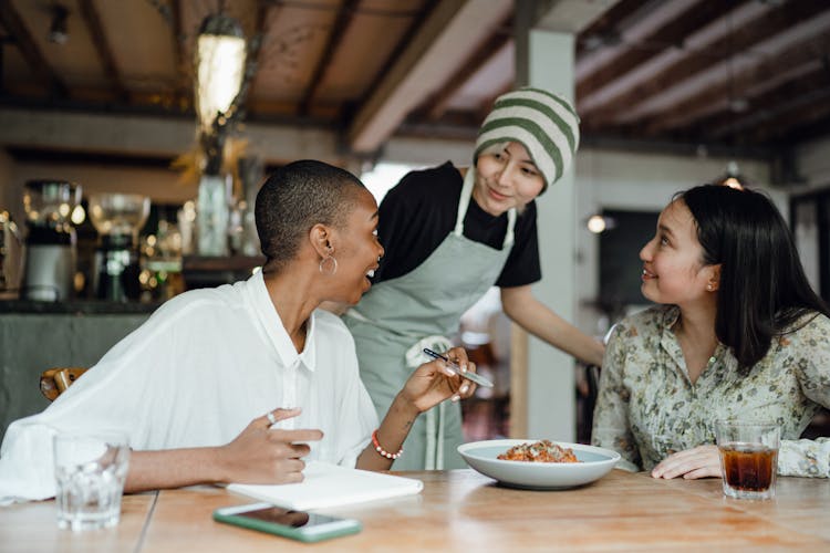 Cheerful Colleagues Tasting Food In Cafeteria