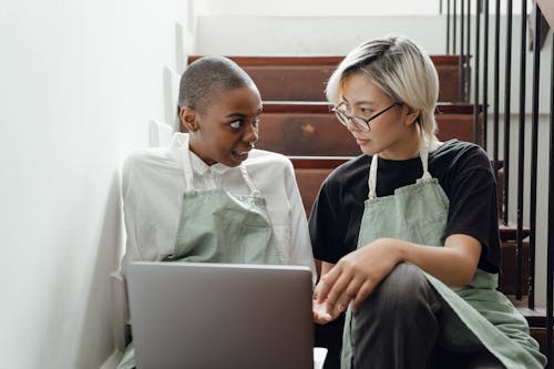 Focused multiracial young women working together on laptop