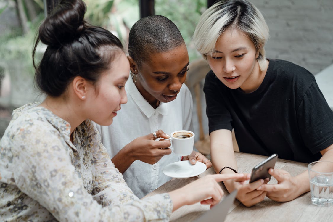 Photo by Ketut Subiyanto from Pexels: https://www.pexels.com/photo/diverse-female-friends-checking-social-media-on-mobile-in-cafe-4350217/